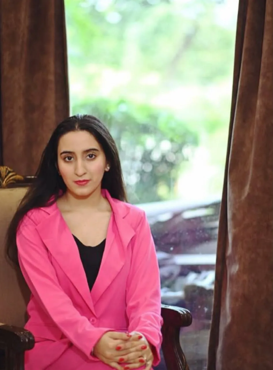 Sukoon Malhotra seated in a pink blazer